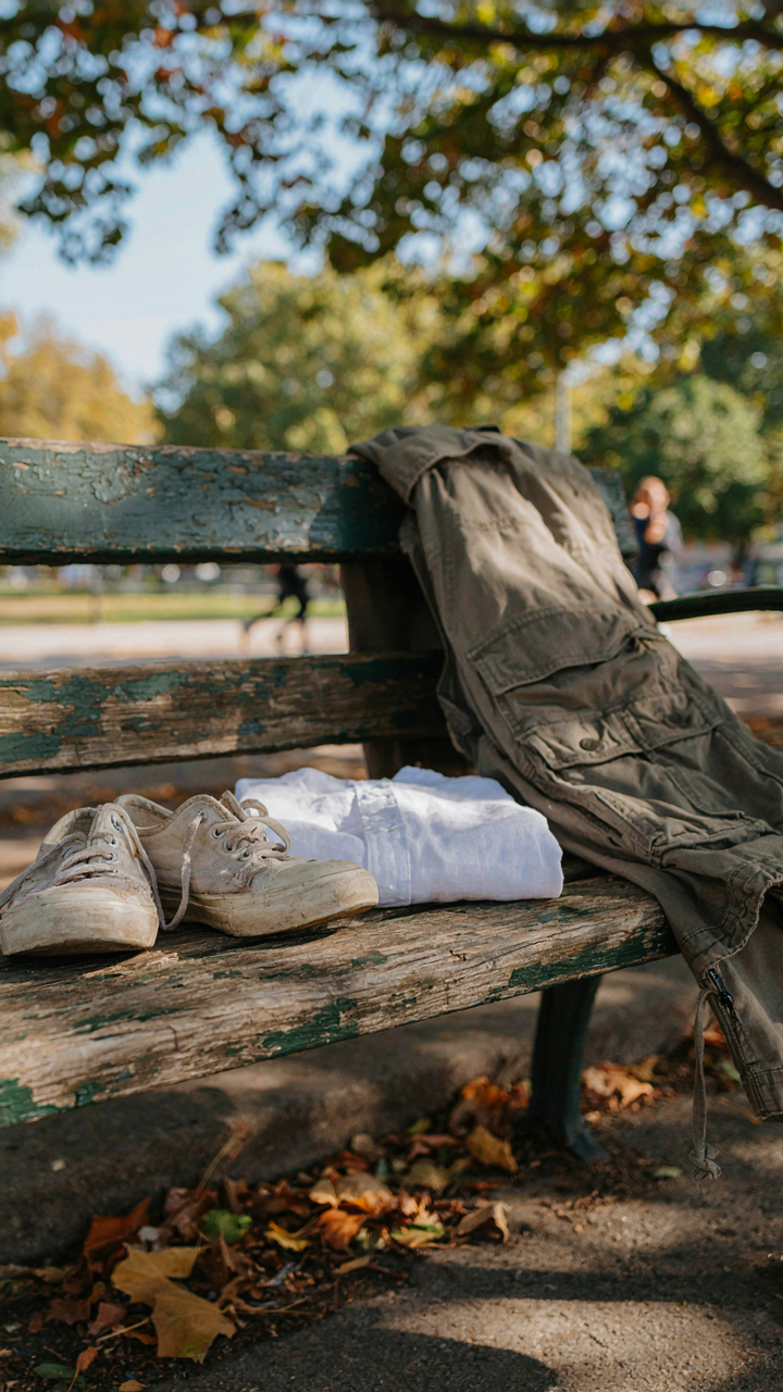 A pair of canvas walking shoes and a linen shirt are next to a bulky cargo pant.
