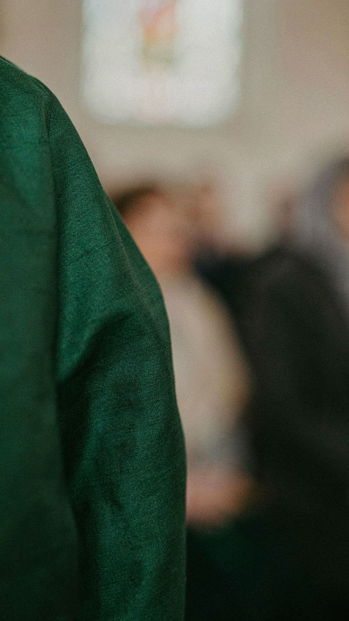 Close-up of a rich emerald green silk fabric on a dress, showing its texture.