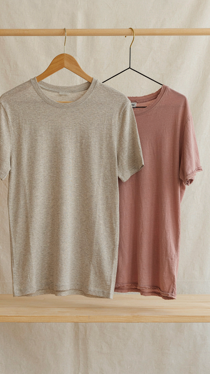 A high-quality merino wool t-shirt hangs next to a faded, pilled, cheap synthetic shirt.