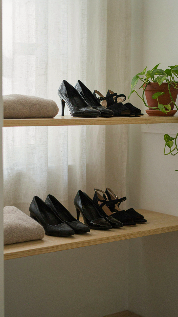 Well-worn black pumps and sandals on a shelf, showing confidence in choice.