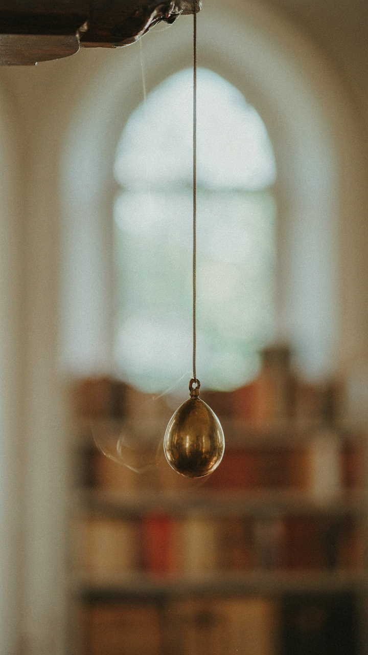 A close-up of a pendulum swinging, demonstrating kinetic energy.