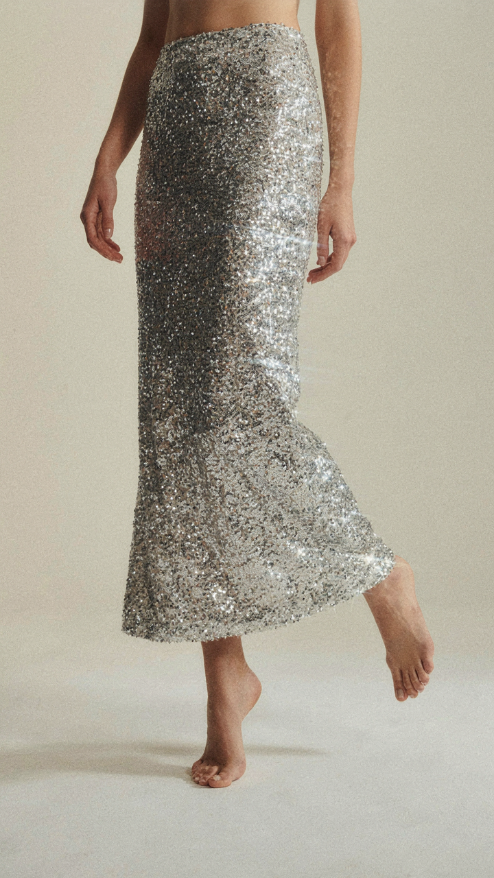 A sequin skirt creating light streaks as a person moves their legs.