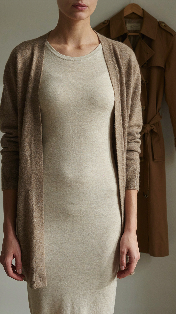 Person wearing a merino base layer and cardigan under a tailored trench coat.
