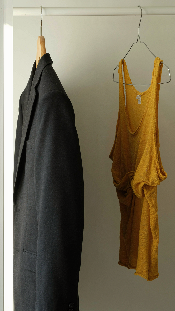 A crisp dark blazer next to a crumpled, cheap, brightly colored top.