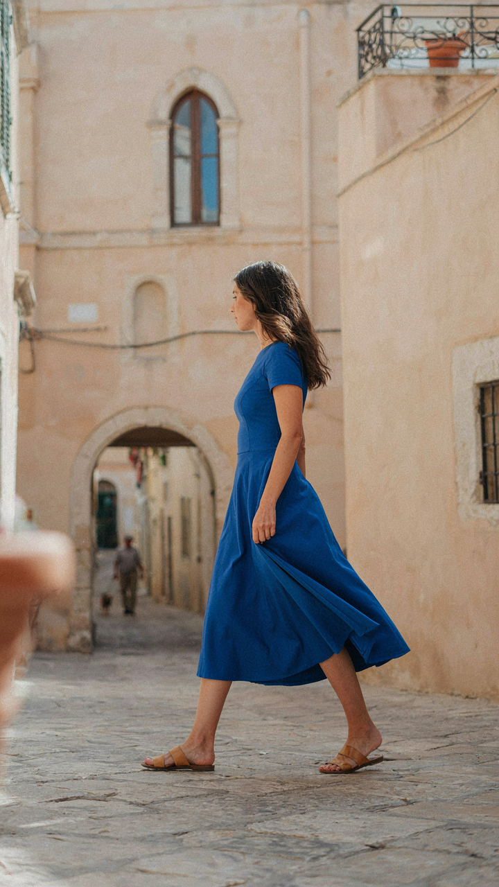 A woman in a midi dress walks, showing the fabric's movement and drape.