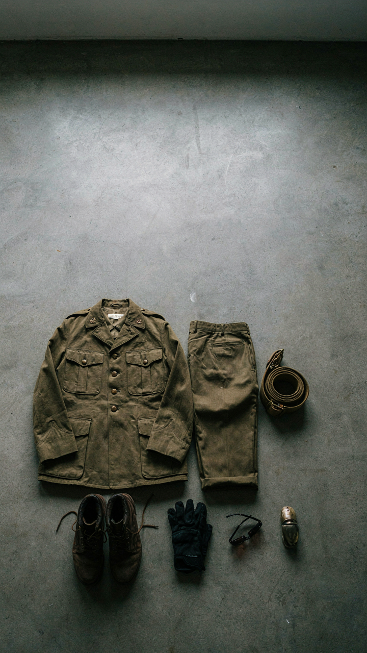 A soldier's neatly folded military uniform with gear laid out.
