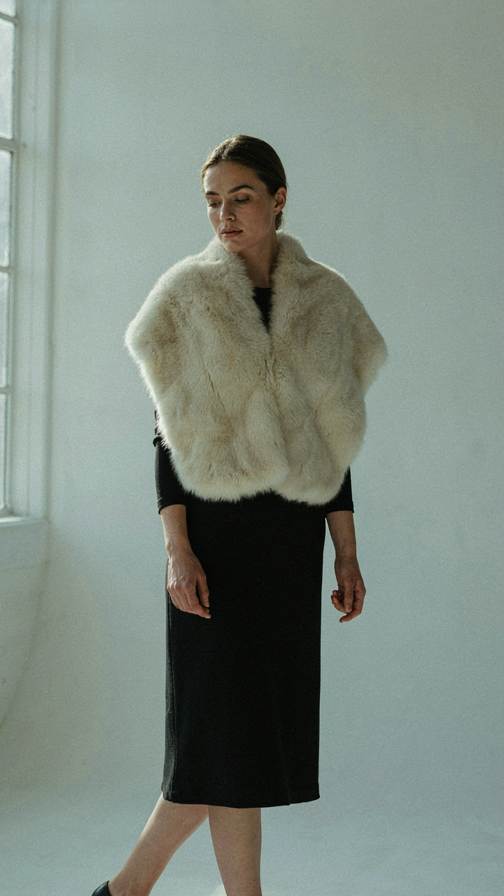 A classic cream faux fur stole as the central piece of an outfit.