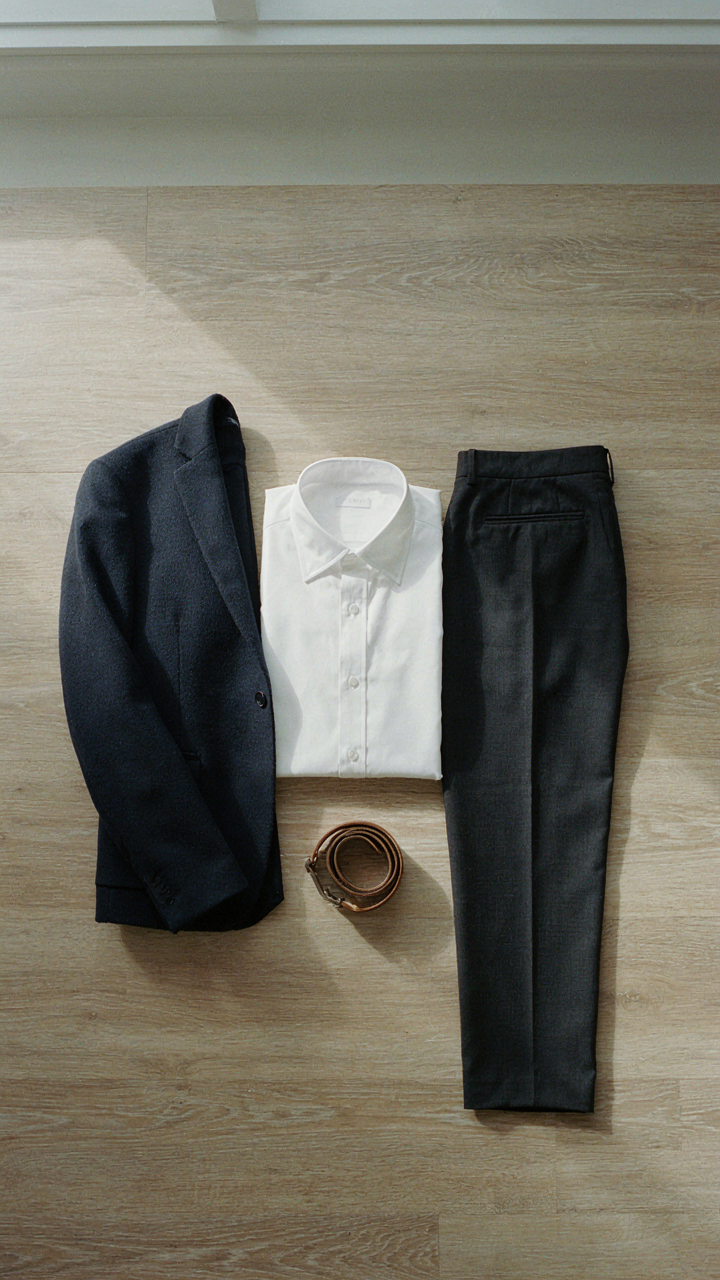 A minimalist capsule wardrobe featuring a navy blazer and dark trousers.