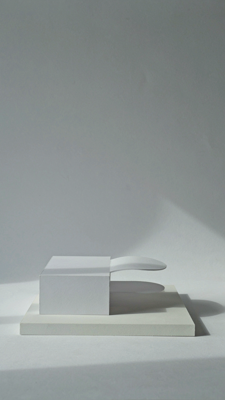 A minimalist architectural model with a subtle curve.