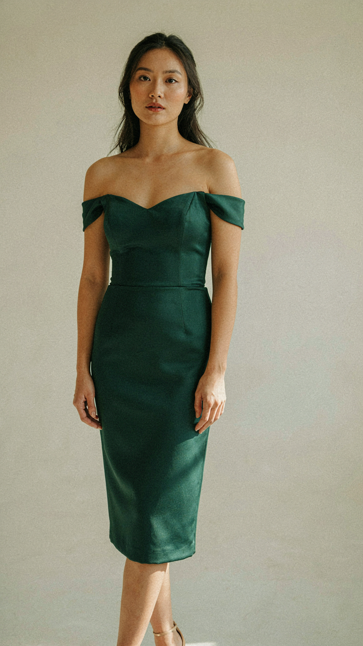Woman confidently wearing an off shoulder cocktail dress that fits well.