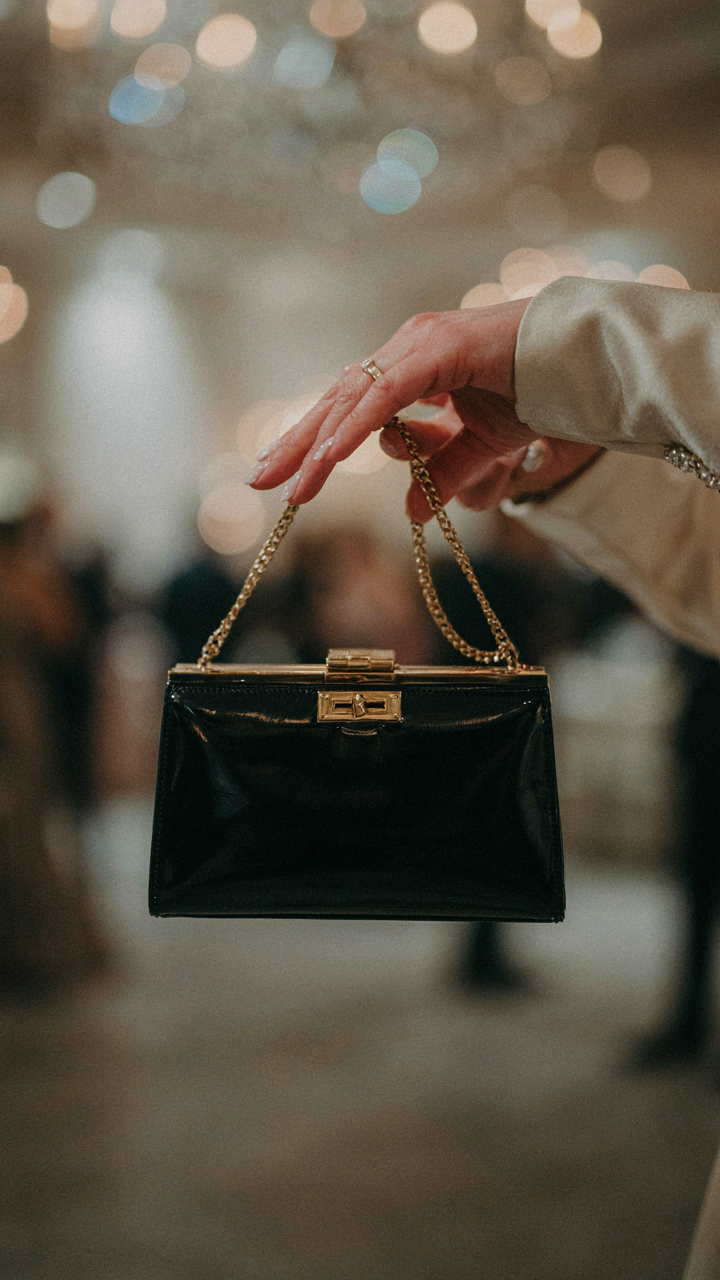 A woman's hand confidently closes a luxury evening bag.