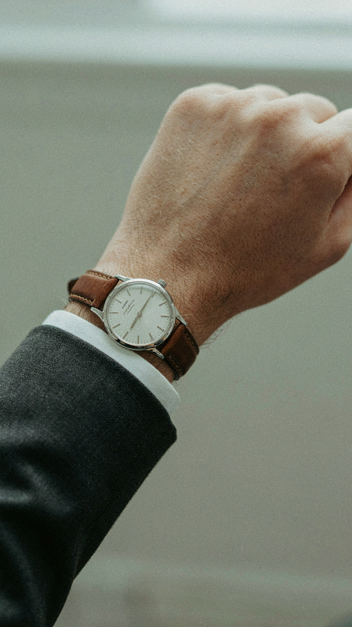 A man wears a classic watch with a tailored suit cuff.