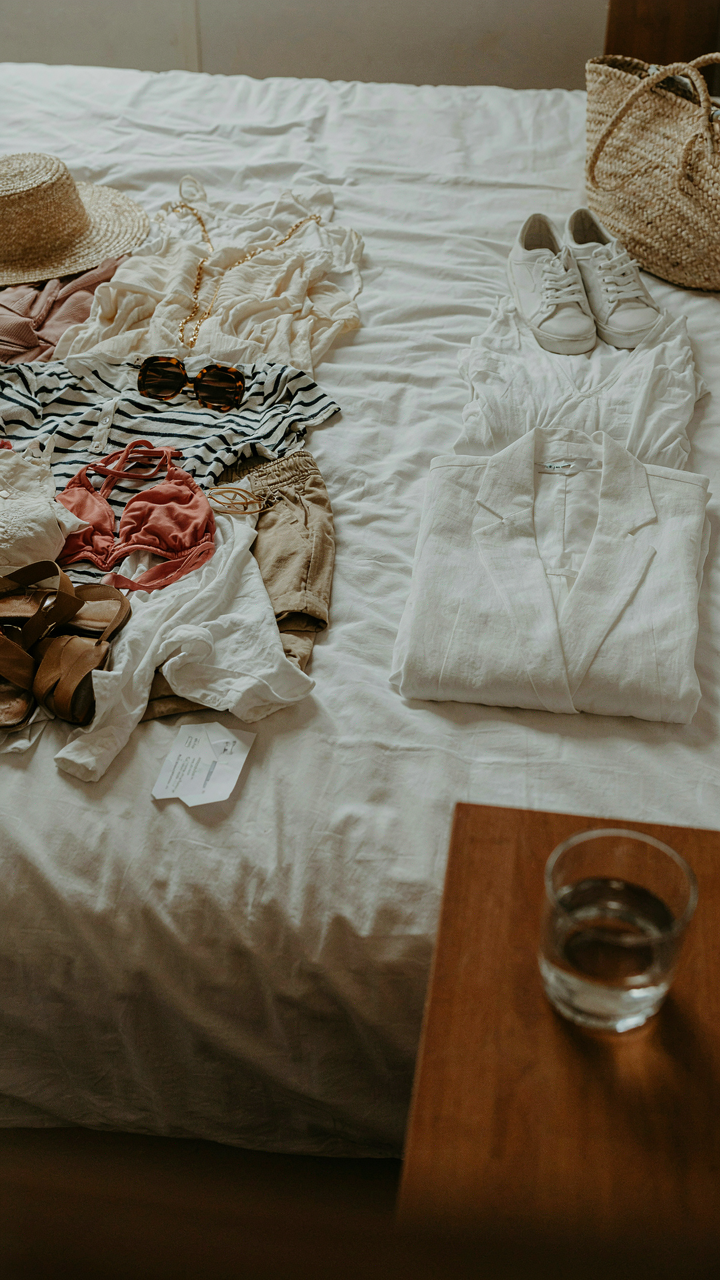 A woman's clothes are sorted into two piles on a bed after a cruise, worn and unworn.