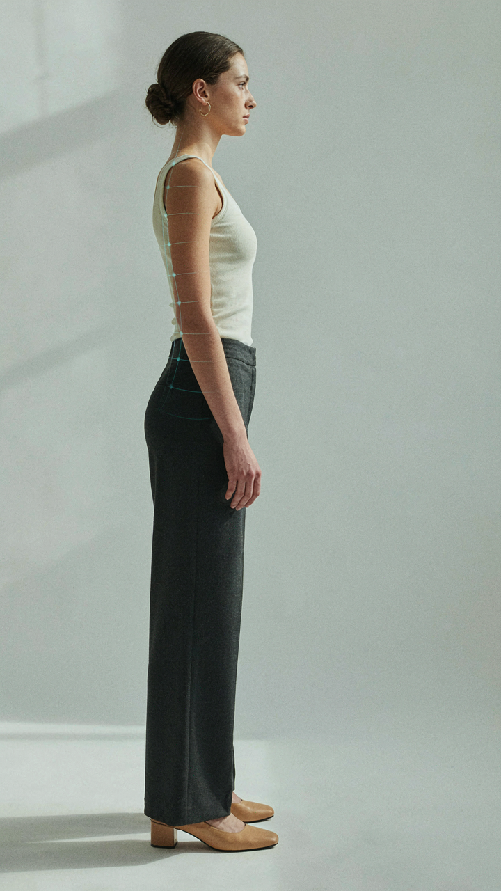 A person stands with good posture in comfortable heels, showing spinal alignment.