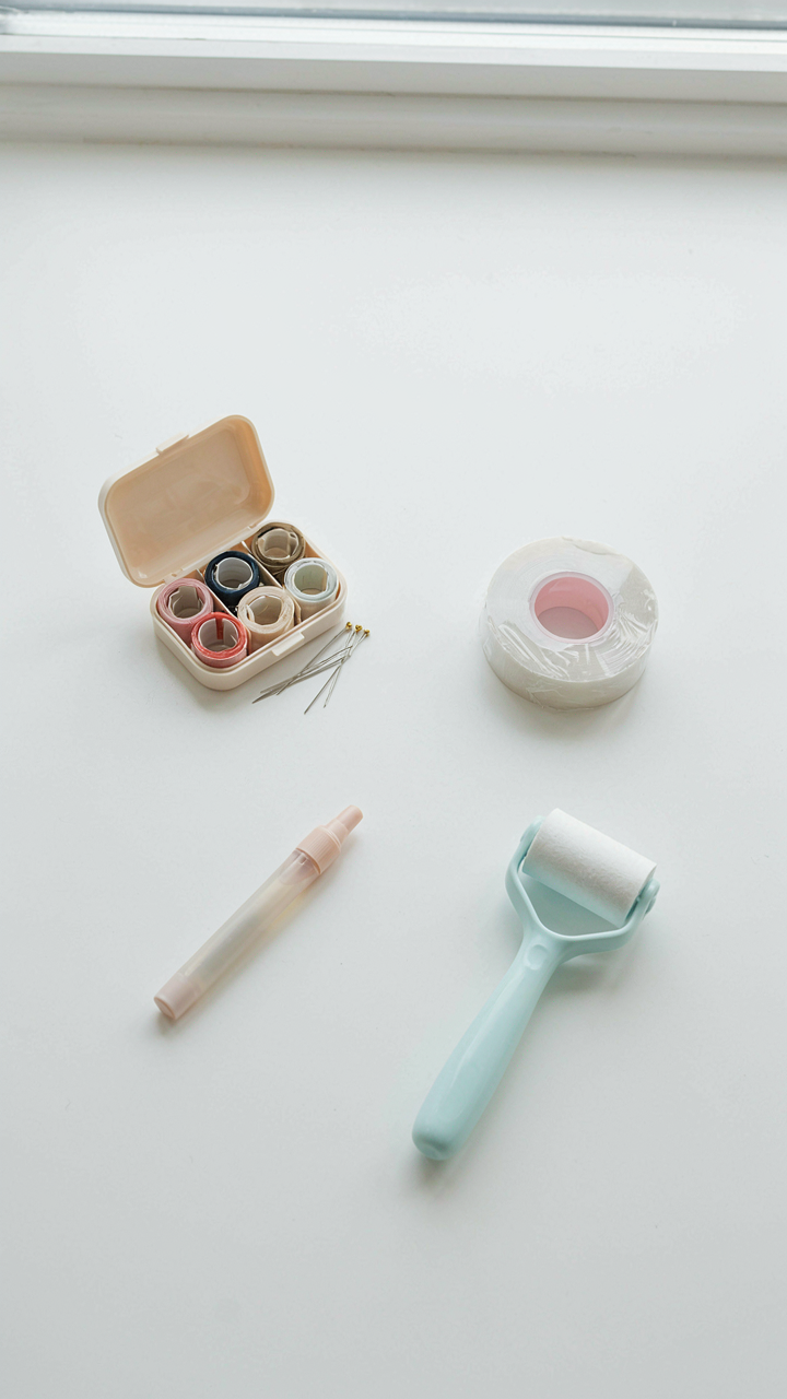 A small emergency kit with sewing supplies, tape, and stain remover.