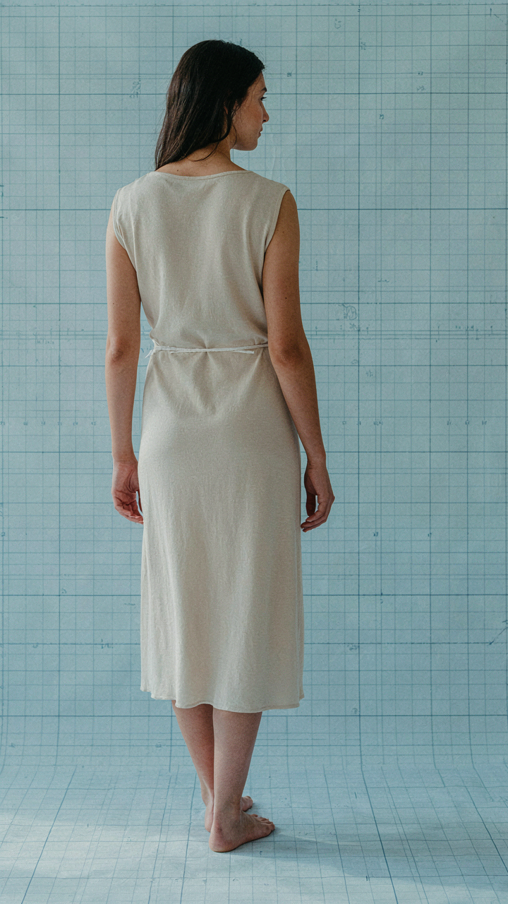 A woman stands against a grid, showing how a wrap dress defines proportions.