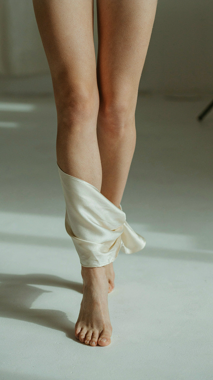 A woman's legs walking with a silk fabric swatch draped over her calf.