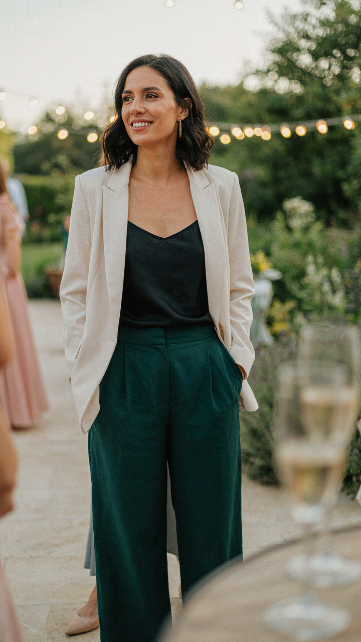 A confident woman in a unique outfit genuinely smiling and engaging at an event.