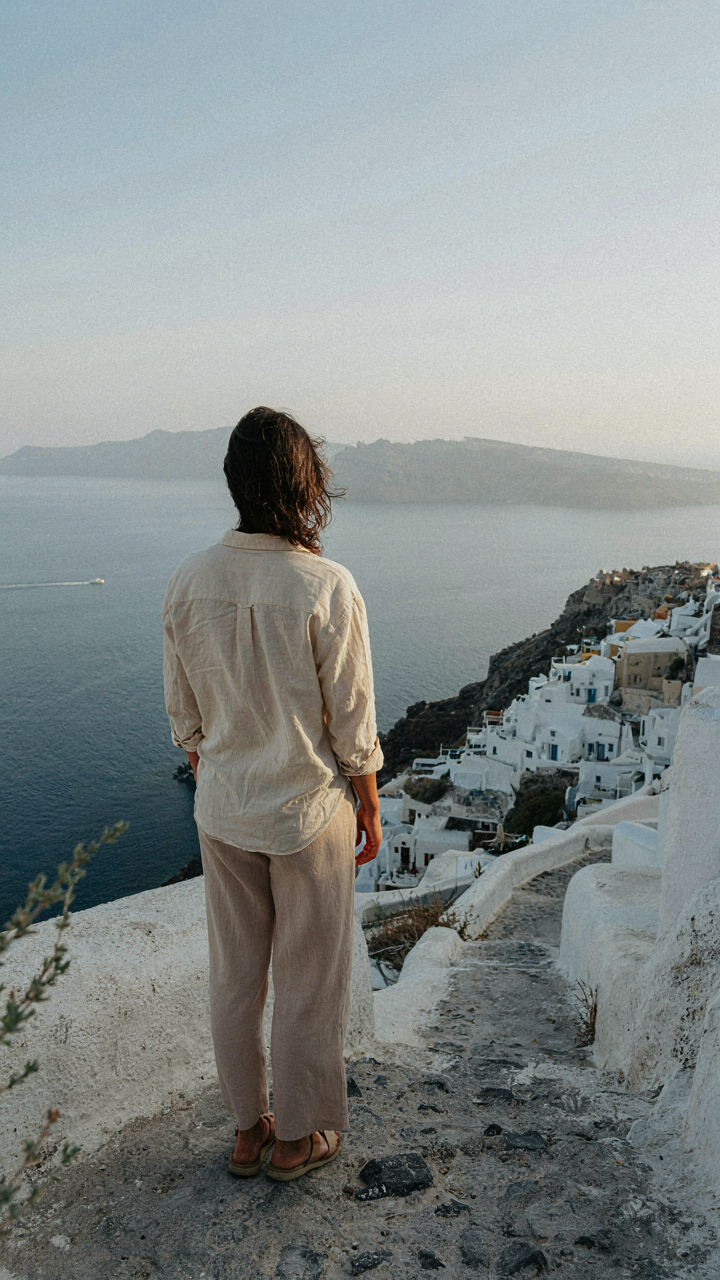 Person in comfortable clothes enjoying a caldera view in Santorini.