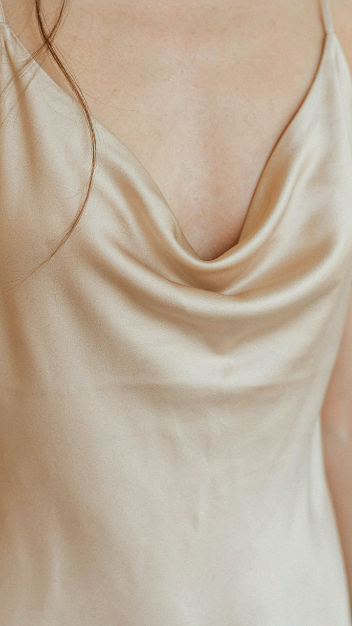 Close-up of a champagne satin slip dress, highlighting its elegant sheen.