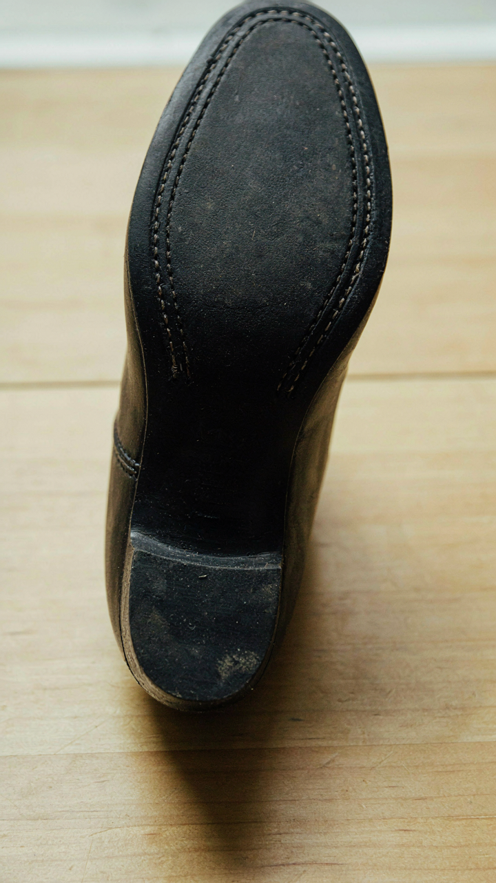 Close-up of a block heel shoe sole with visible, dense stitching.