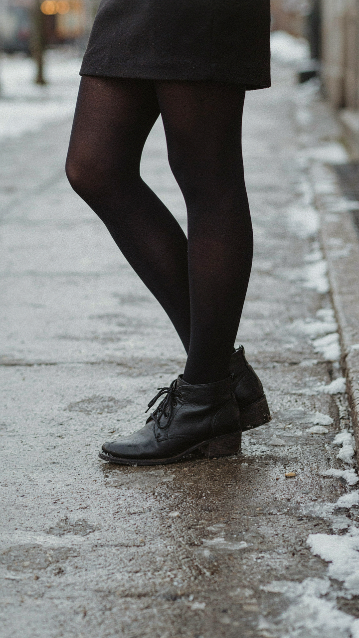Black opaque tights and closed-toe ankle boots with a short cocktail dress.