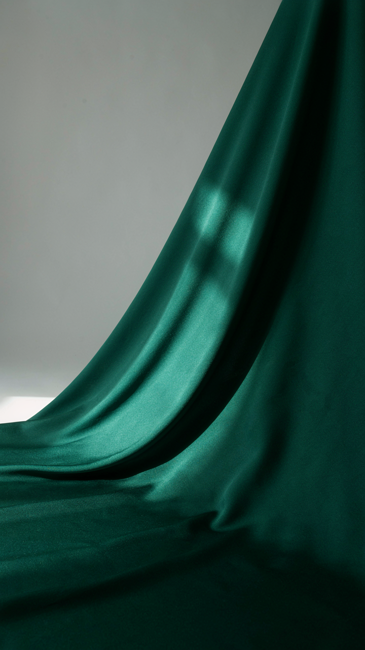 Close-up of a smooth, rich jewel-toned silk fabric with clean lines.
