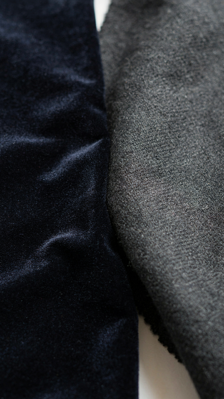 Close up of rich velvet fabric next to a swatch of finely woven wool.