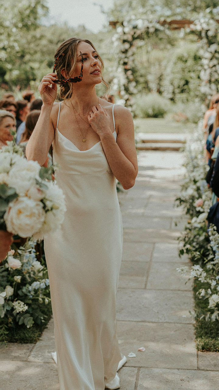 A person carefully removes their sunglasses before a wedding ceremony.