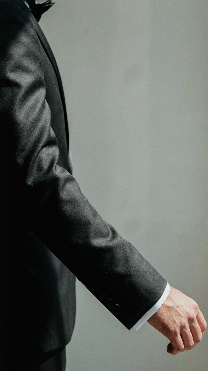 Close-up of a perfectly tailored long sleeve on a tuxedo pantsuit.