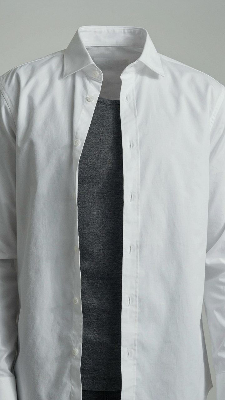 A person wears a merino wool base layer under a white dress shirt.