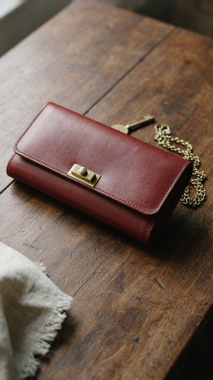 A vintage structured leather clutch shows fine stitching and polished hardware.