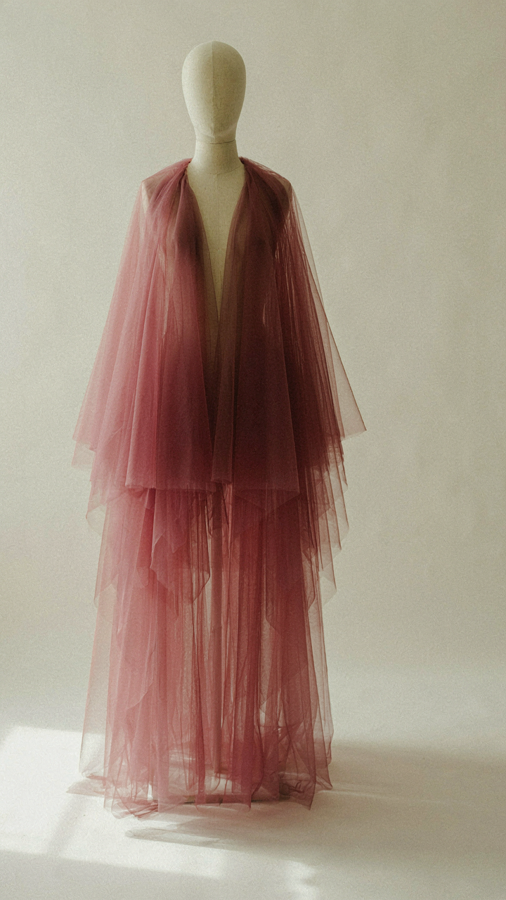 Rich burgundy tulle fabric drapes elegantly, showing subtle layers.
