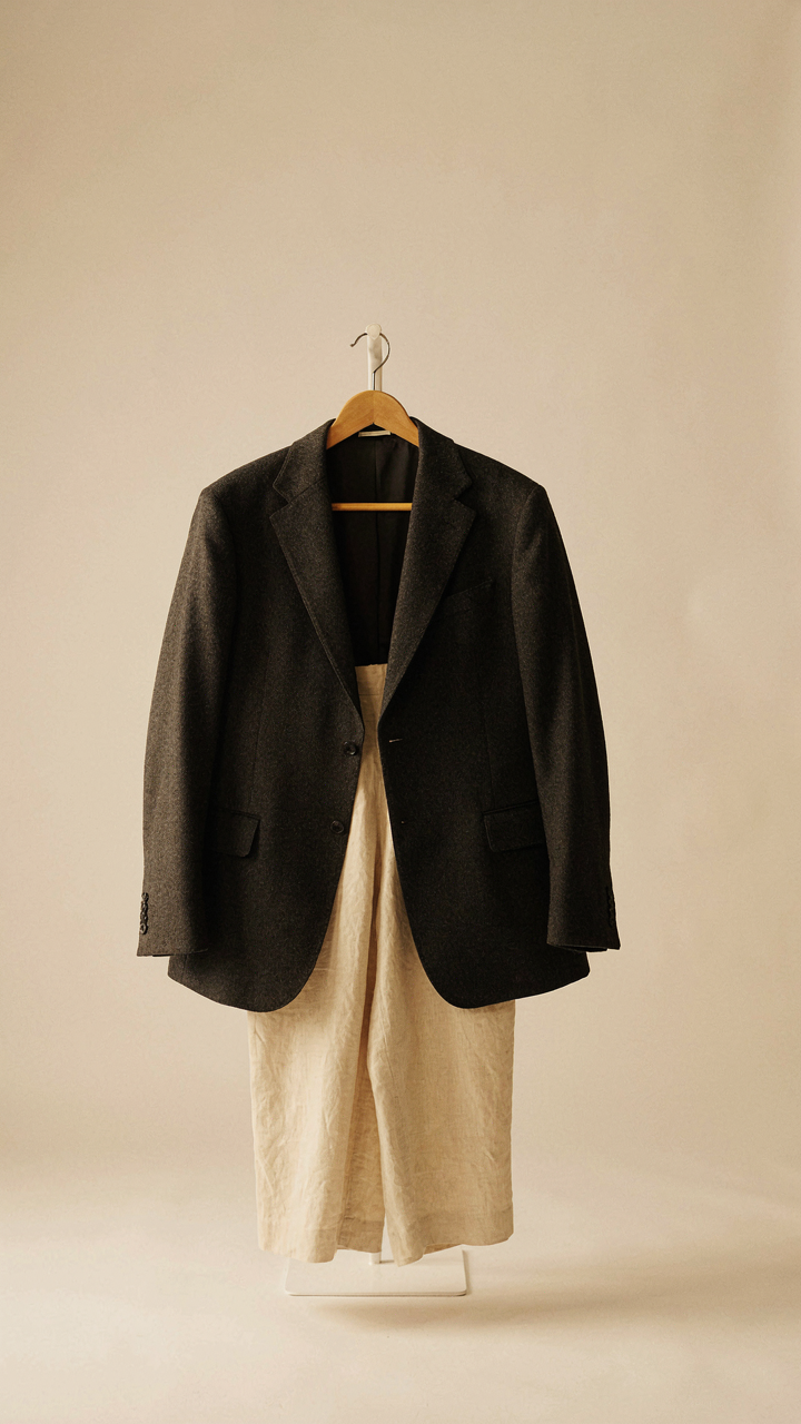 A structured wool blazer paired with relaxed linen trousers, a smart casual cocktail attire mix.