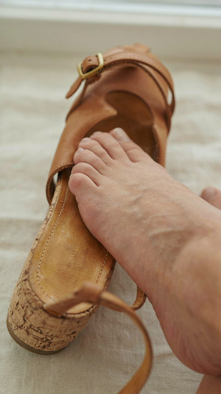 A cross-section shows a foot resting on a molded cork footbed with an ankle strap.
