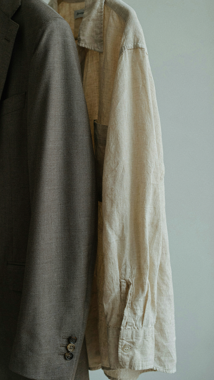 A tailored linen blend blazer sleeve next to a wrinkled cotton shirt sleeve.
