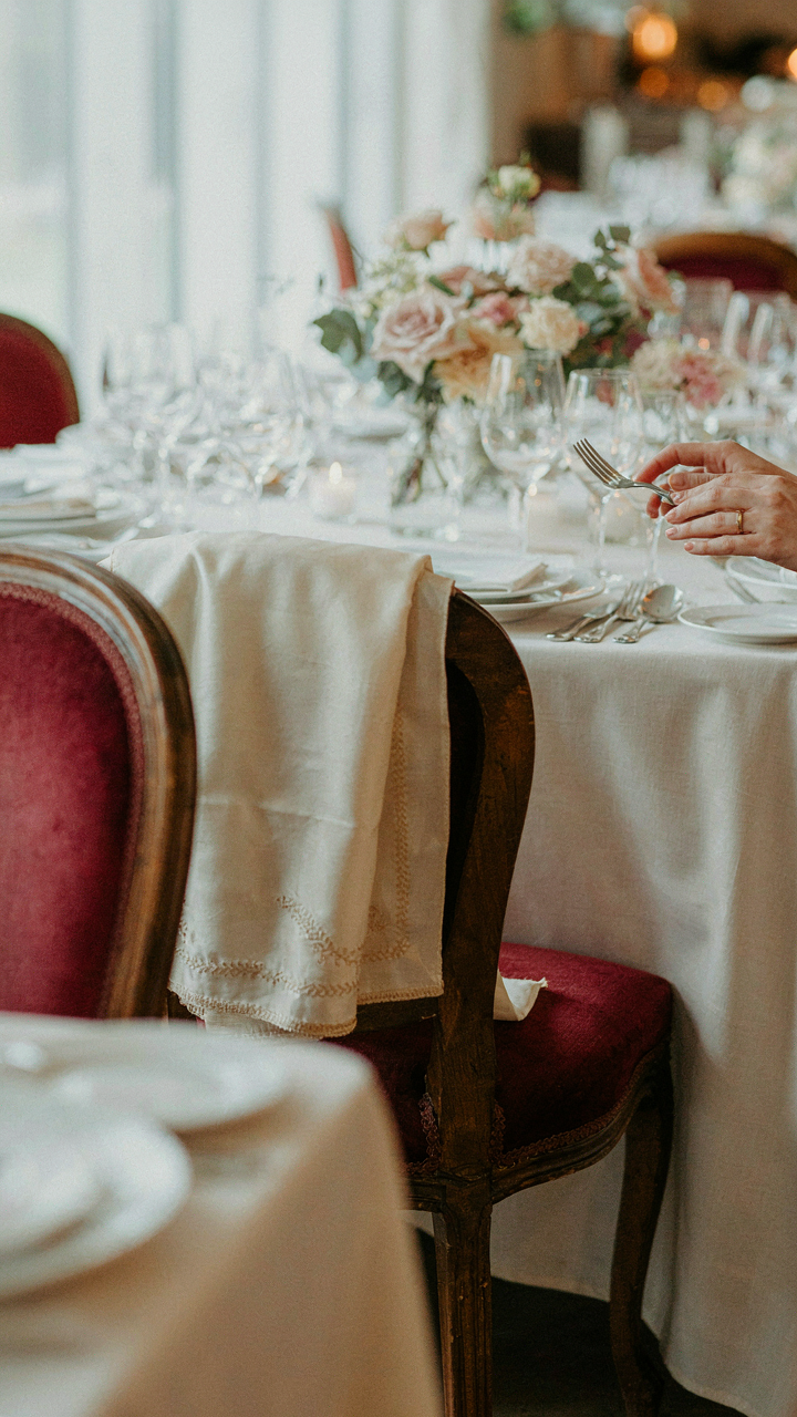 A folded shawl rests on the back of a chair at a wedding reception.