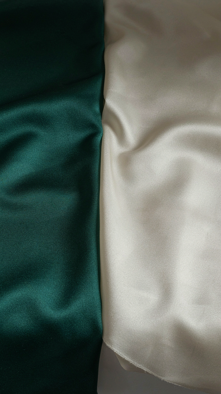 Heavy and light satin fabric swatches under contrasting soft and bright lighting.