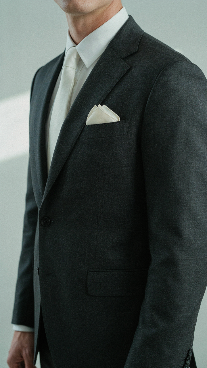 An impeccably tailored jacket with a single, neat silk pocket square.