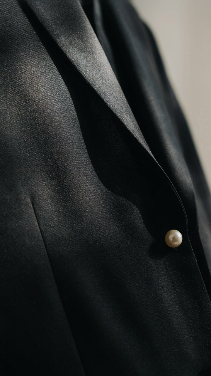 Close up of a luxurious silk charmeuse tuxedo dress fabric shining brightly.