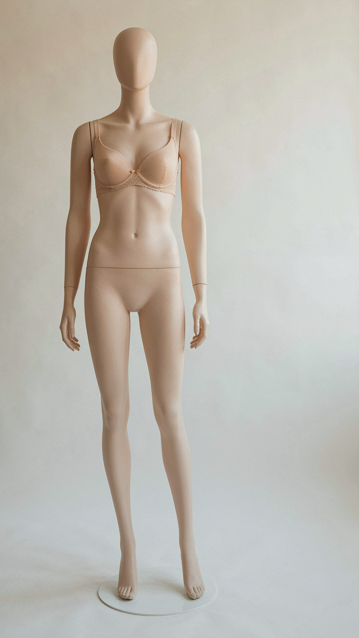 A supportive nude colored bra sits on a mannequin, ready for a formal dress.