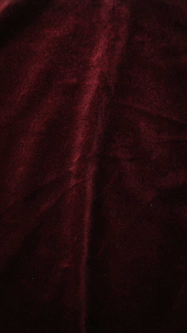 Close-up of luxurious dark velvet fabric with subtle highlights.