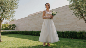 A woman in a vintage style wedding guest dress, blending styles from past eras.