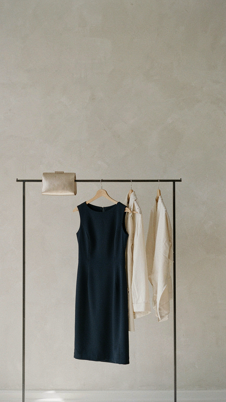 A capsule wardrobe with a navy dress, metallic clutch, and silk wrap.