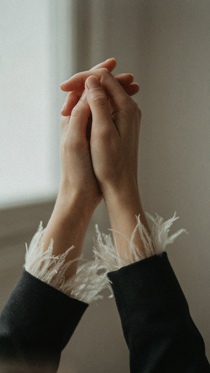 A subtle feather trim on the cuff of a woman's dark sleeve.
