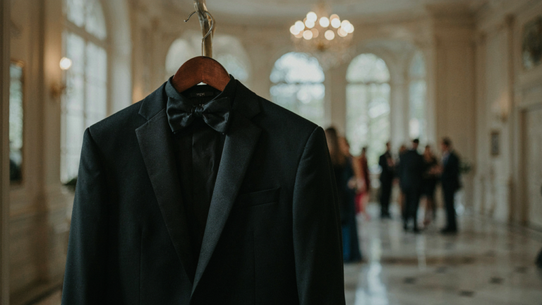 A black tuxedo jacket and bow tie hang, ready for a formal event.