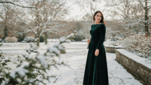 Woman in a long sleeve velvet winter wedding guest dress smiles at an outdoor event.
