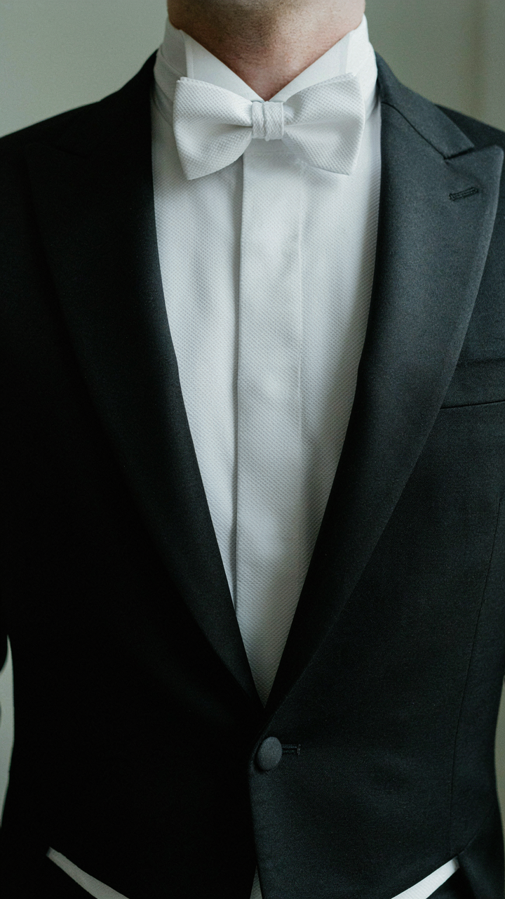 A man wears a white tie with a tailcoat and white piqu&eacute; shirt.