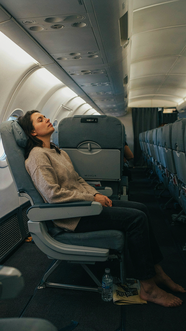 Serene woman fully reclined and relaxed in her airplane seat.